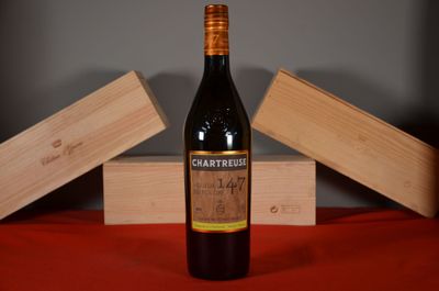 a bottle of wine sitting on a table next to two wooden boxes