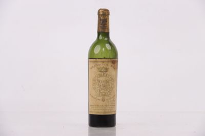 une vieille bouteille de vin posée sur une table blanche