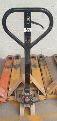 un cariste assis sur une palette dans un parking