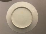a white plate with a white rim sitting on a table
