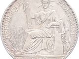 une vieille pièce d'argent sur laquelle figure la statue d'une femme assise sur une chaise