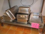 many trays of food sitting on a metal shelf