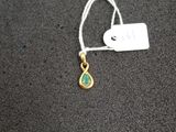 un gros plan d'un collier doré et vert orné d'une étiquette