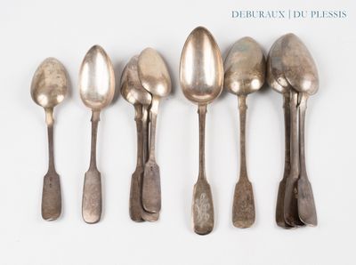 six silver spoons are lined up in a row on a white surface