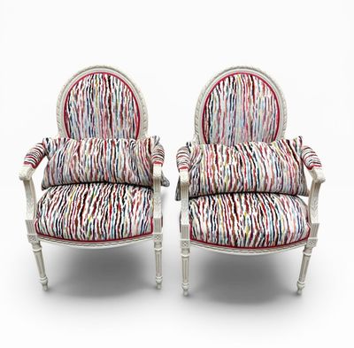 deux chaises blanches sur lesquelles sont posés des coussins rembourrés à rayures colorées