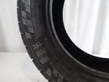 tires are lined up on a white surface with a white curtain in the background