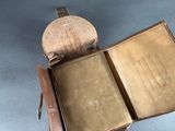 a brown leather case with a book inside of it