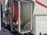 a large white truck with a hose attached to it ' s side