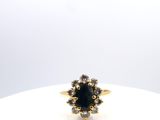 un gros plan d'une bague en or sertie d'une pierre noire entourée de diamants blancs