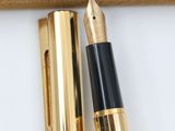 a gold pen and a black pen sitting in a box