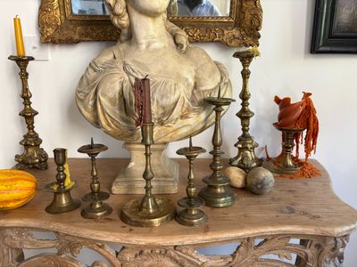 a bust of a woman sitting on top of a table next to candles
