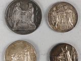 four different types of coins are shown on a white surface