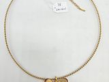 a gold necklace with a butterfly charm on a chain