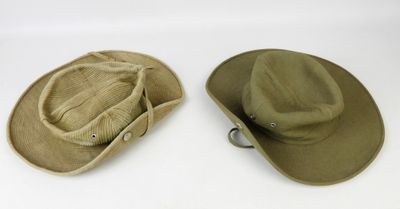 deux chapeaux sont posés l'un à côté de l'autre sur une surface blanche