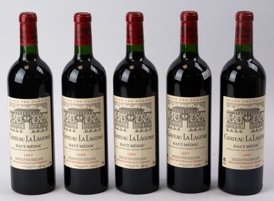 quatre bouteilles de vin sont alignées sur une table