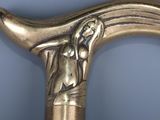 a close up of a gold colored cane with a dog on it