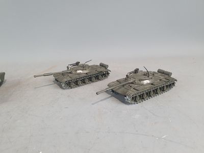 three toy tanks are sitting on a white surface with a white background