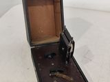 une petite boîte en bois munie d'une serrure, posée sur une table