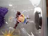 a toy figure in a plastic box with a purple flower