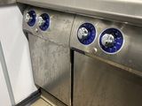 trois boutons bleus sur le côté d'une cuisinière en acier inoxydable