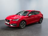 Une voiture rouge est garée dans une pièce au sol noir.