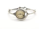 montre-bracelet en argent avec des chiffres romains sur le cadran