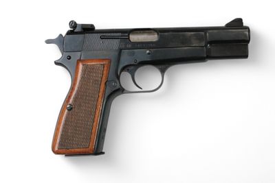 un gros plan d'un pistolet sur une surface blanche avec un fond blanc