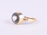 a close up of a gold ring with a pearl in the center