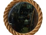 un miroir accroché au mur, entouré d'une corde
