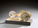 une petite maquette de machine à vapeur posée sur un socle