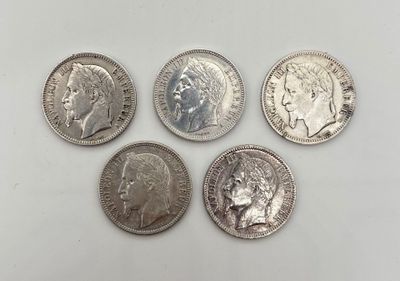 quatre types différents de pièces d'argent sur une surface blanche