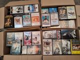 un grand nombre de dvd dans une boîte posée sur le sol