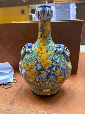 un vase posé sur une table, à côté d'une paire de ciseaux