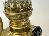 a gold colored lamp that is on a white table