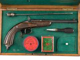 a wooden box with a gun and other items in it