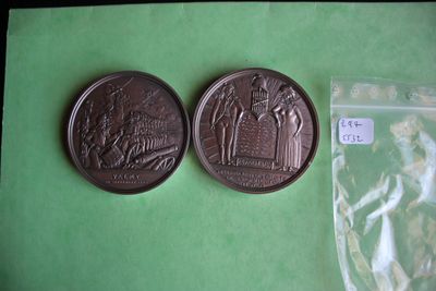 two coins sitting on a green surface next to a plastic bag