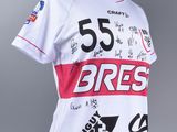 a close up of a white jersey with black and red writing on it