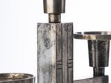 a silver metal candle holder with two cups on it