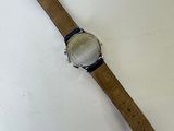 an image of a watch on a white surface with a blue strap