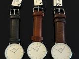 three different styles of watches are displayed on a black surface