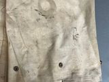 an old pair of pants hanging on a clothes rack on a blue wall