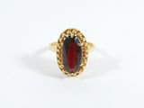 gros plan d'une bague en or avec une pierre rouge