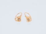 une paire de boucles d'oreilles en or sur fond blanc