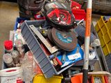 a pile of junk sitting on the ground next to a trash can