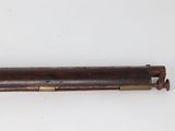 an old gun with a wooden barrel on a white surface