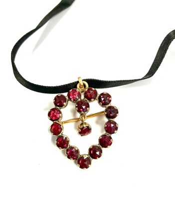 an image of a necklace with red stones on a black ribbon