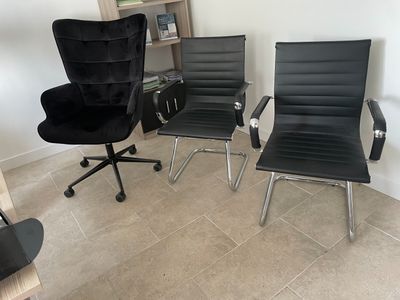 deux chaises de bureau noires placées l'une à côté de l'autre dans une pièce