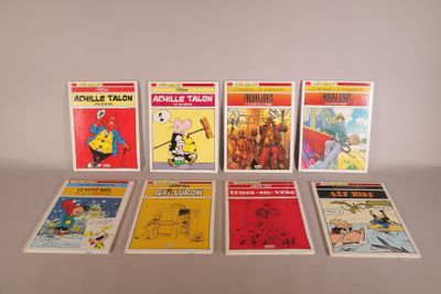 several comics are lined up in a row on a table