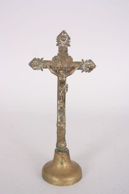 brass crucift with a cross on top of it on a white background