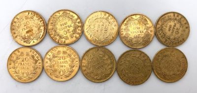 un groupe de pièces d'or posées sur une surface blanche